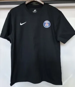 PSG 2026/27 T-Shirt - Front View Black PSG Nike T‑shirt on a hanger; white Nike swoosh on the left chest and PSG crest on the right chest.