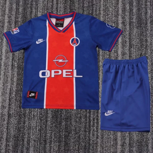 PSG soccer jersey in blue with red vertical stripe and Opel sponsor; includes Nike logos and matching blue shorts on a carpeted floor.