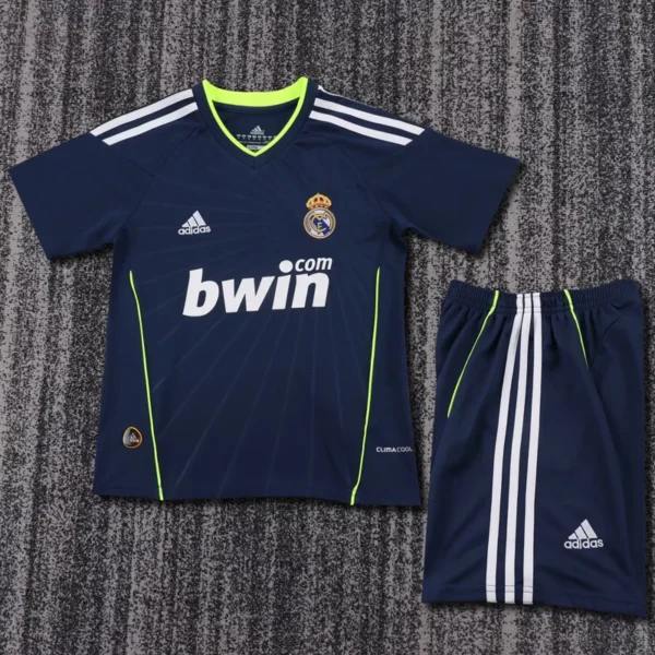 Real Madrid 2010/11 Retro Away Kids Kit Fan Version - Front View Navy Real Madrid football jersey with neon green trim and matching shorts on a textured surface, featuring bwin sponsor and Adidas logos