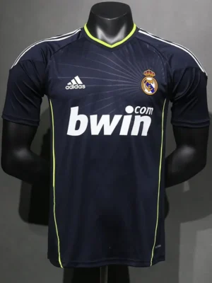 Navy Real Madrid football jersey on a mannequin, with lime piping, Adidas logo, and bwin sponsor front and center.
