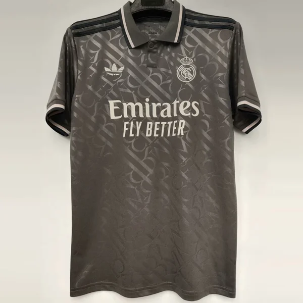 Real Madrid 2024/25 Third Jersey Fan Version - Front View Dark gray Real Madrid football shirt on a hanger, showing the Emirates sponsor and club crest on the chest.