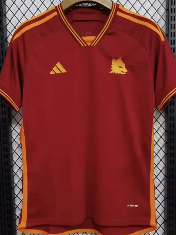 Roma 2023/24 Home Jersey Fan Version - Front View Maroon Adidas sports jersey hanging on a hanger with yellow trim and a wolf crest on the left chest.