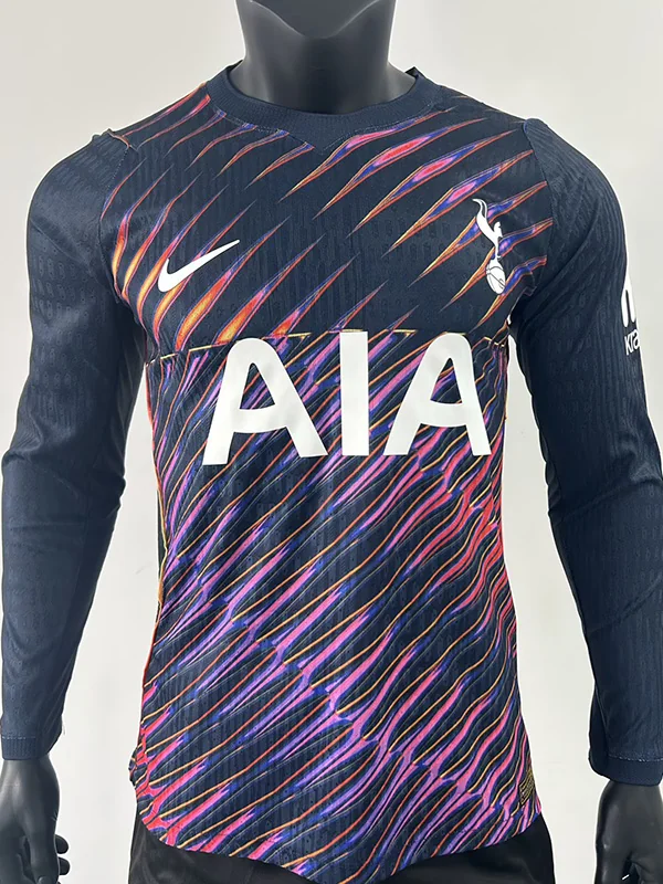 Front view of a navy Tottenham Hotspur soccer jersey with neon pink/orange diagonal stripes, white AIA sponsor, and Nike swoosh.
